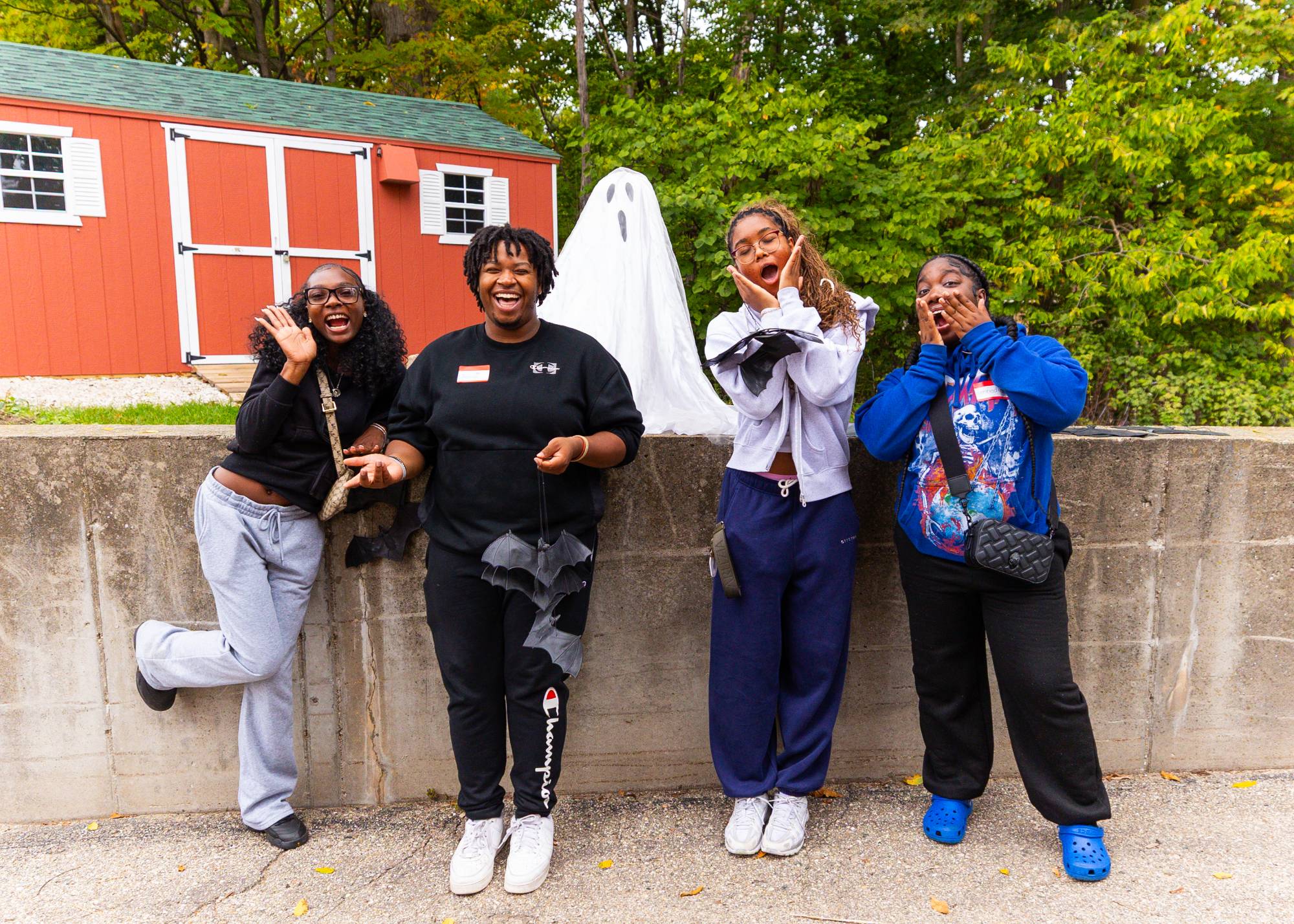 group posing with a ghost figure making scared faces